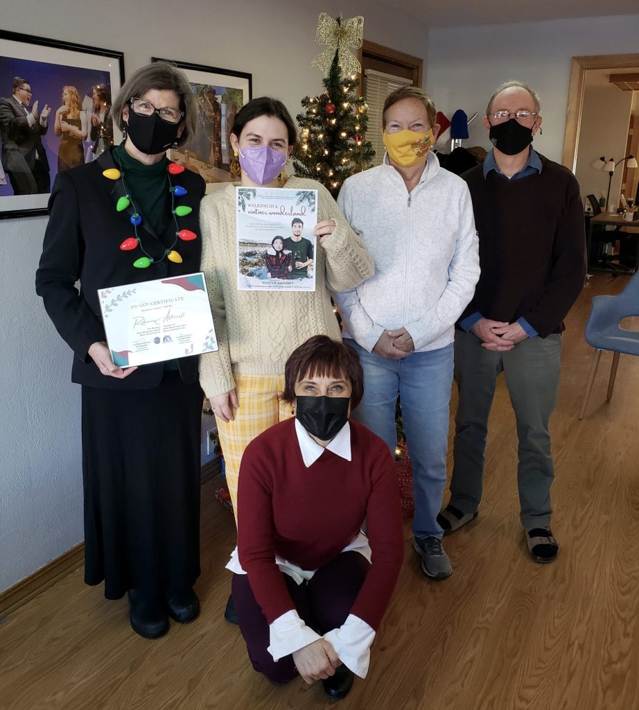 Contest winner Rebecca Ashcraft stands in front of Christmas tree in Arts Missoula office alongside Arts Missoula staff and one of the judges.